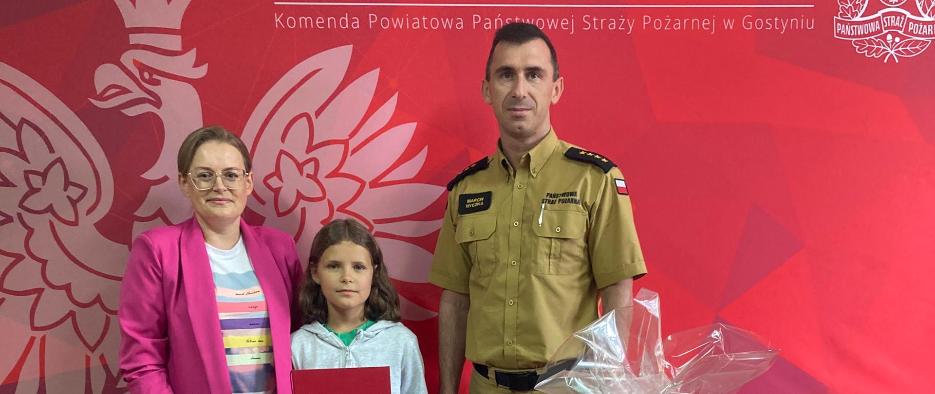 Na zdjęciu komendant PSP, mama Hani oraz Hania.