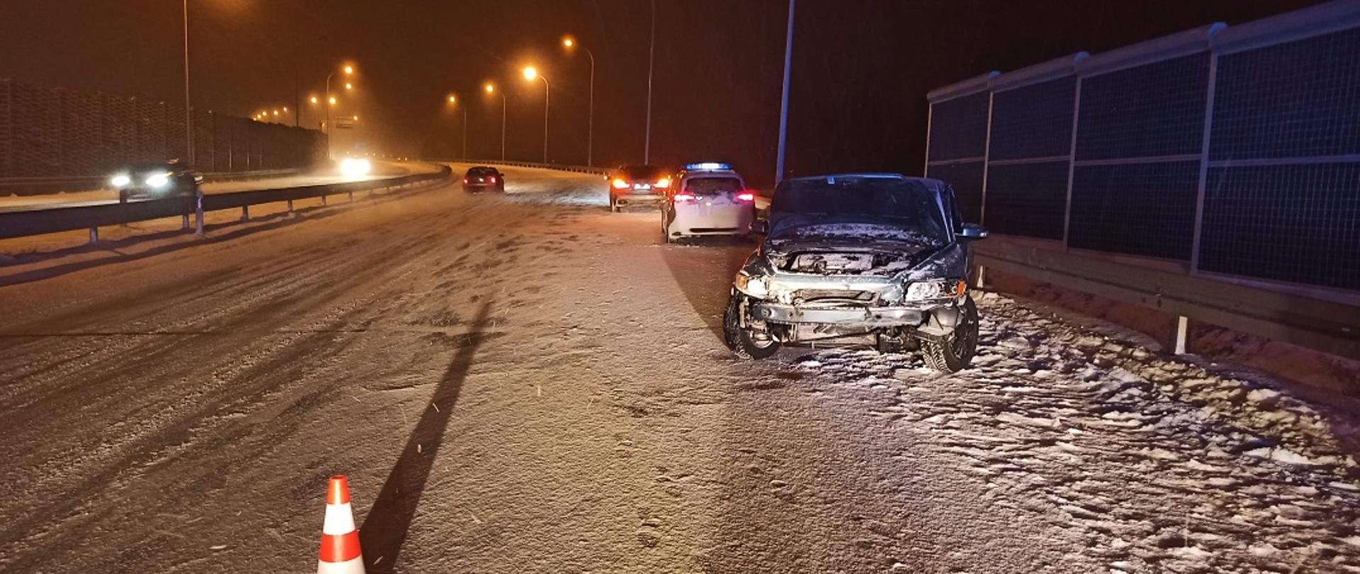 Na zdjęciu widać uszkodzony pojazd marki Volvo który znajduje się na pasie awaryjnym drogi S7, w oddali widać samochód policyjny