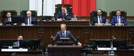 Premier Donald Tusk podczas przemówienia w Sejmie 7 marca 2025 r. W tle Marszałek Sejmu Szymon Hołownia.
