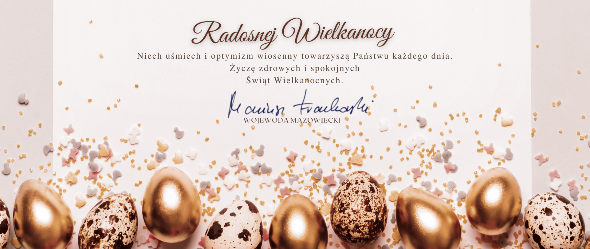 grafika z życzeniami Wojewody Mazowieckiego Mariusza Frankowskiego. Treść życzeń: Niech uśmiech i optymizm wiosenny towarzyszą Państwu każdego dnia. Życzę zdrowych i spokojnych Świąt Wielkanocnych. Na grafice widoczne jajka oraz konfetti położone na beżowym tle.
