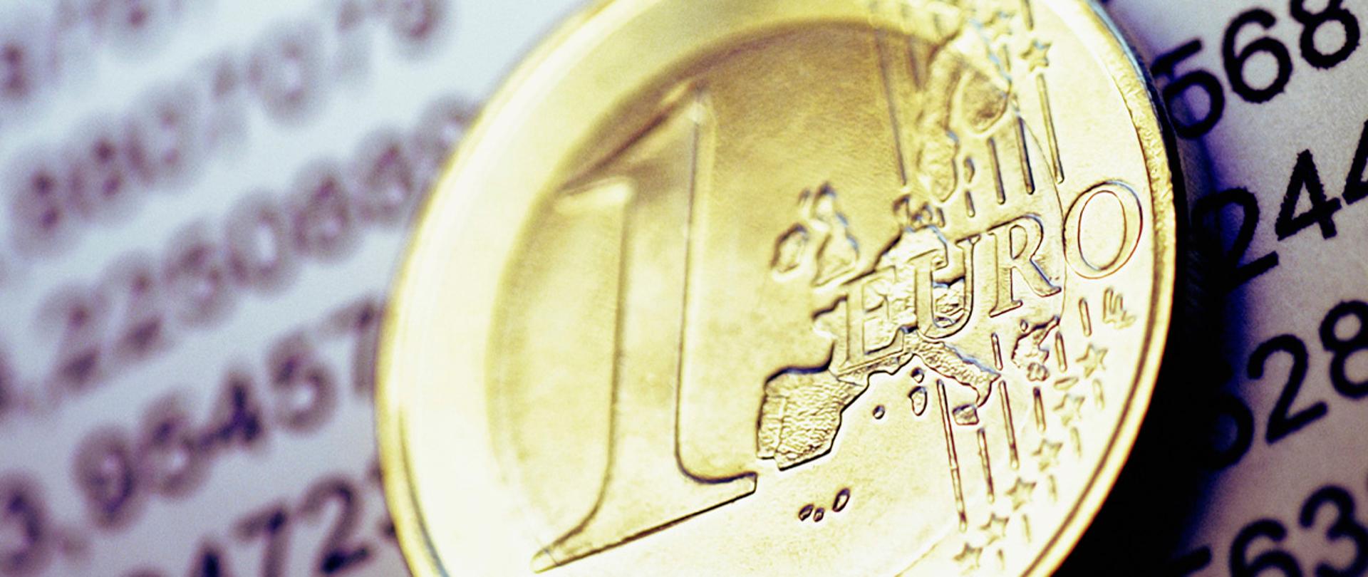 Moneta 1 euro na tle arkusza z cyframi