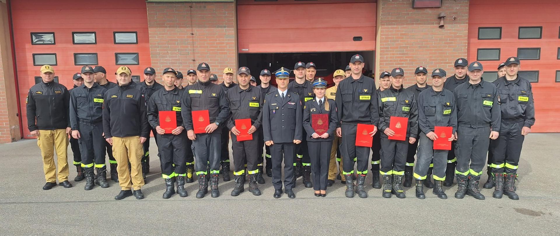 zdjęcie grupowe uroczystej zbiórki. Awansowani trzymają w dłoniach teczki z aktami mianowania