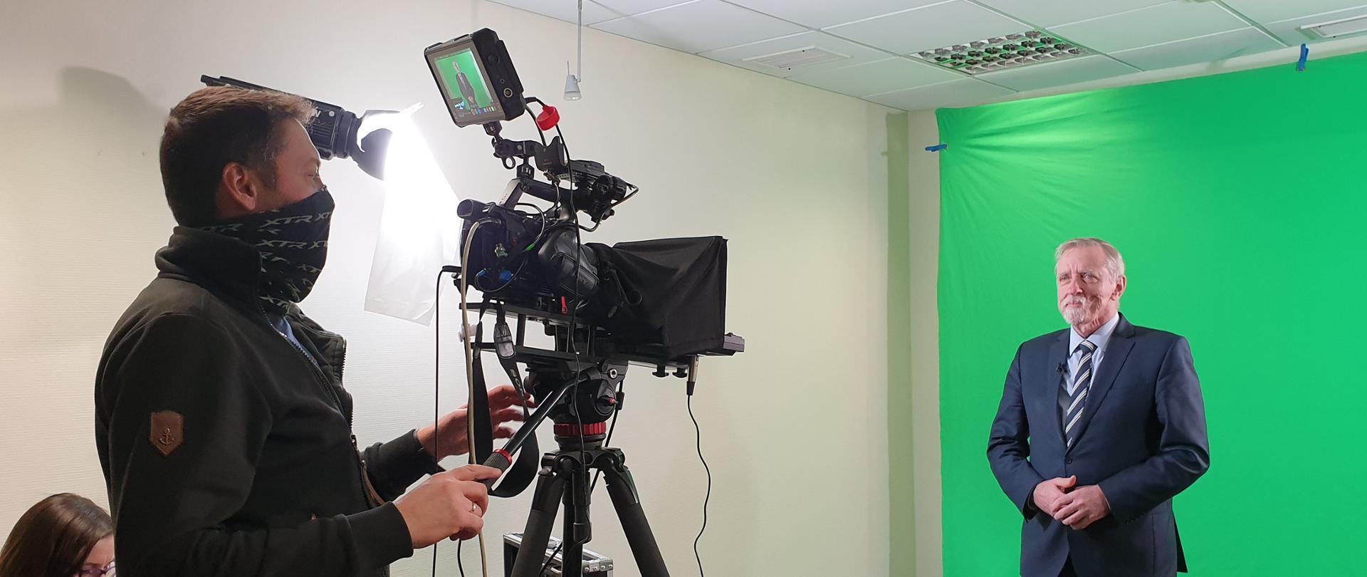 Elegancko ubrany mężczyzna na zielonym tle podczas nagrywania