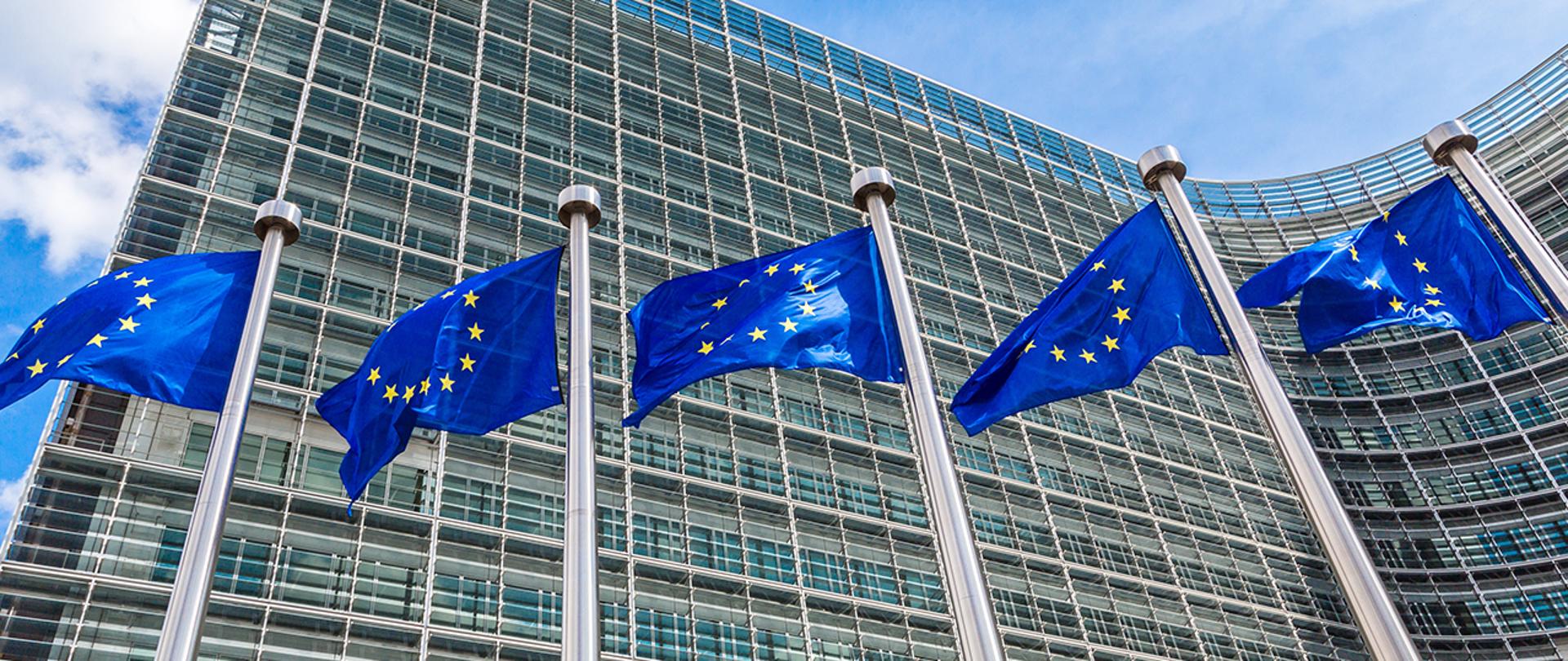 pięć wiszących flag Unii Europejskiej na tle budynku 