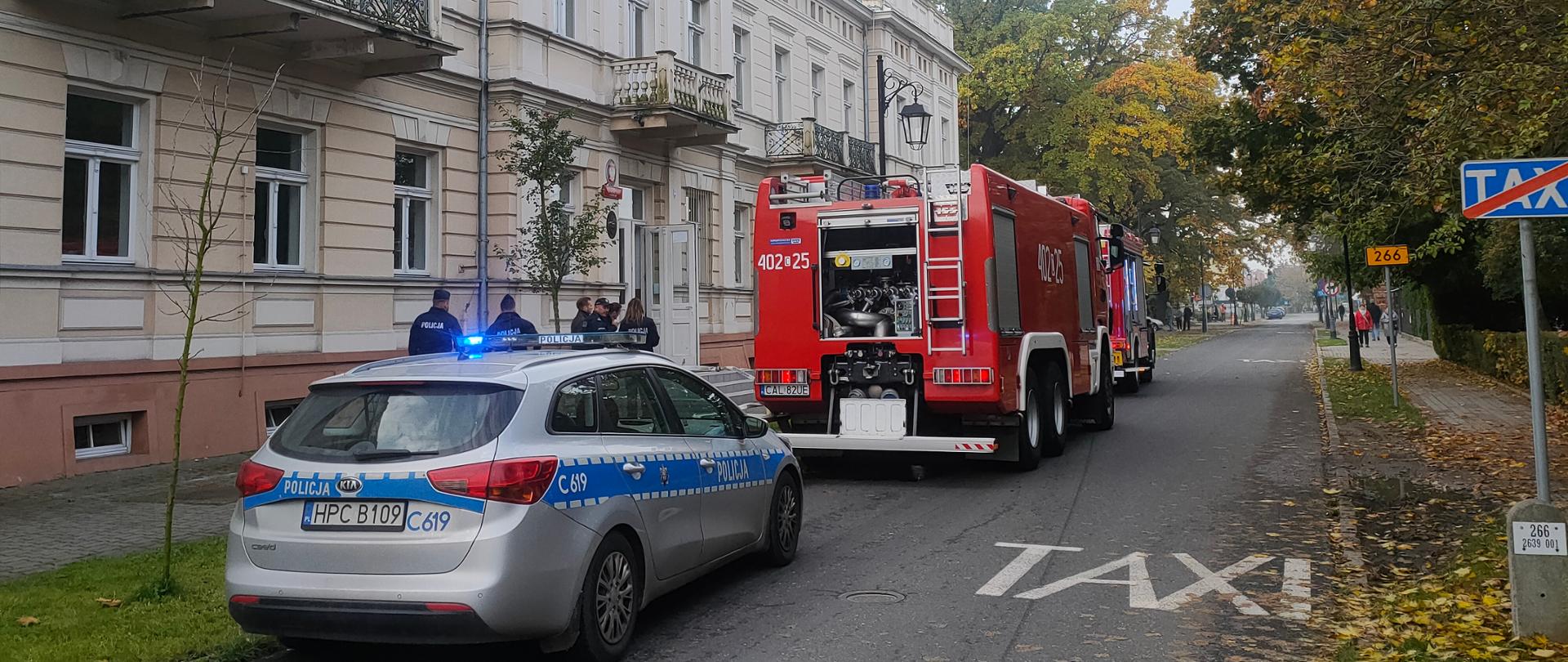 samochód policyjny i pożarniczy przed budynkiem Liceum Ogólnokształcącego podczas ćwiczeń
