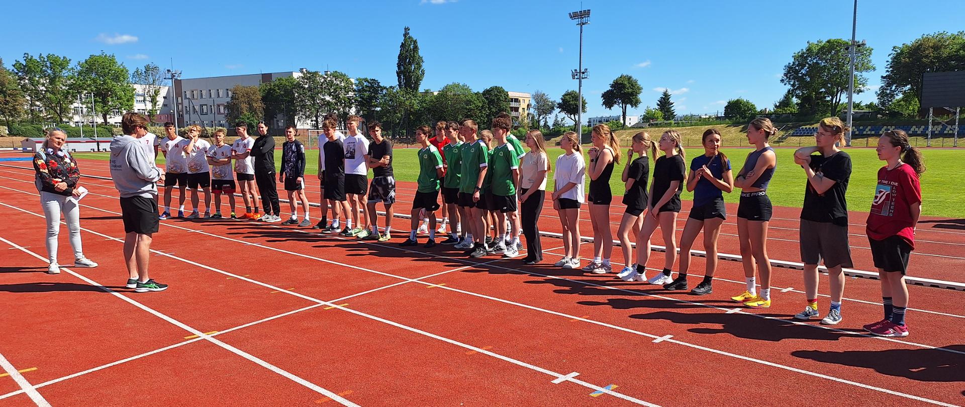 Uczniowie przygotowujący się do startu na stadionie podczas Indywidualnych Mistrzostw Powiatu Nakielskiego w lekkoatletyce.