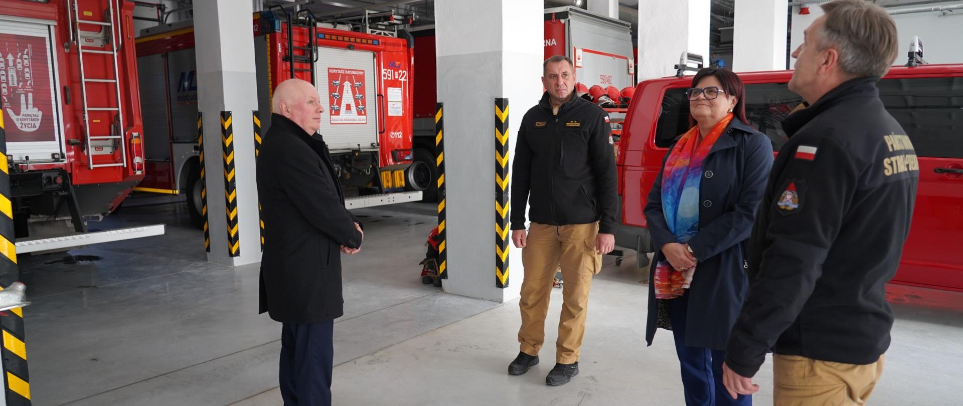 Władze powiatu i strażacy na garażu