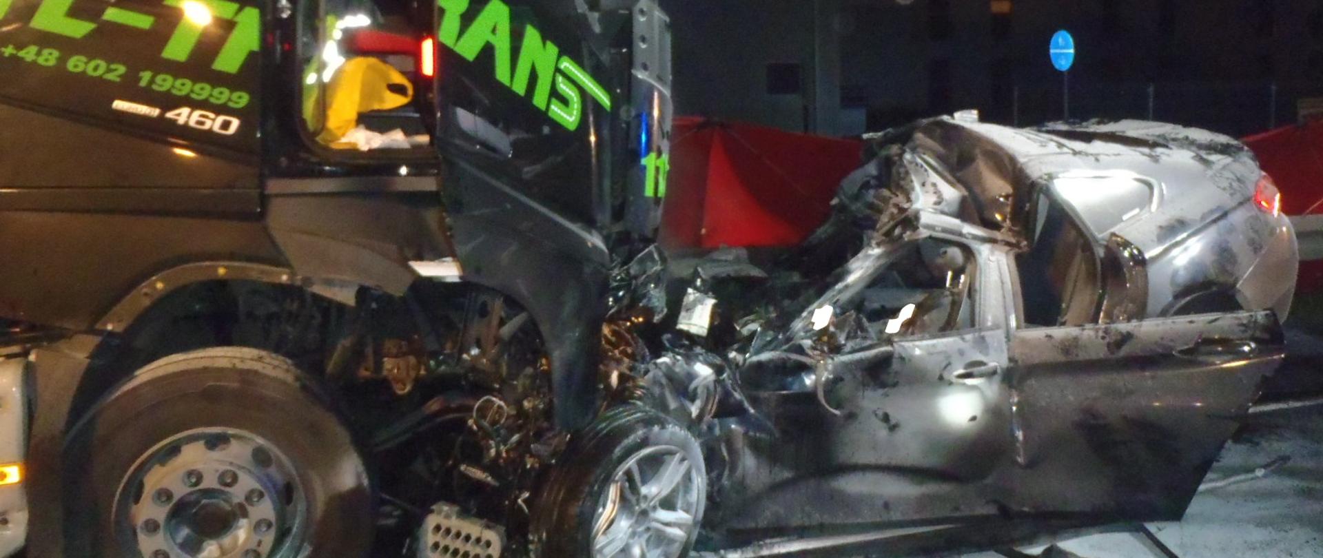 Zniszczony samochód osobowy wbity w przód samochodu ciężarowego