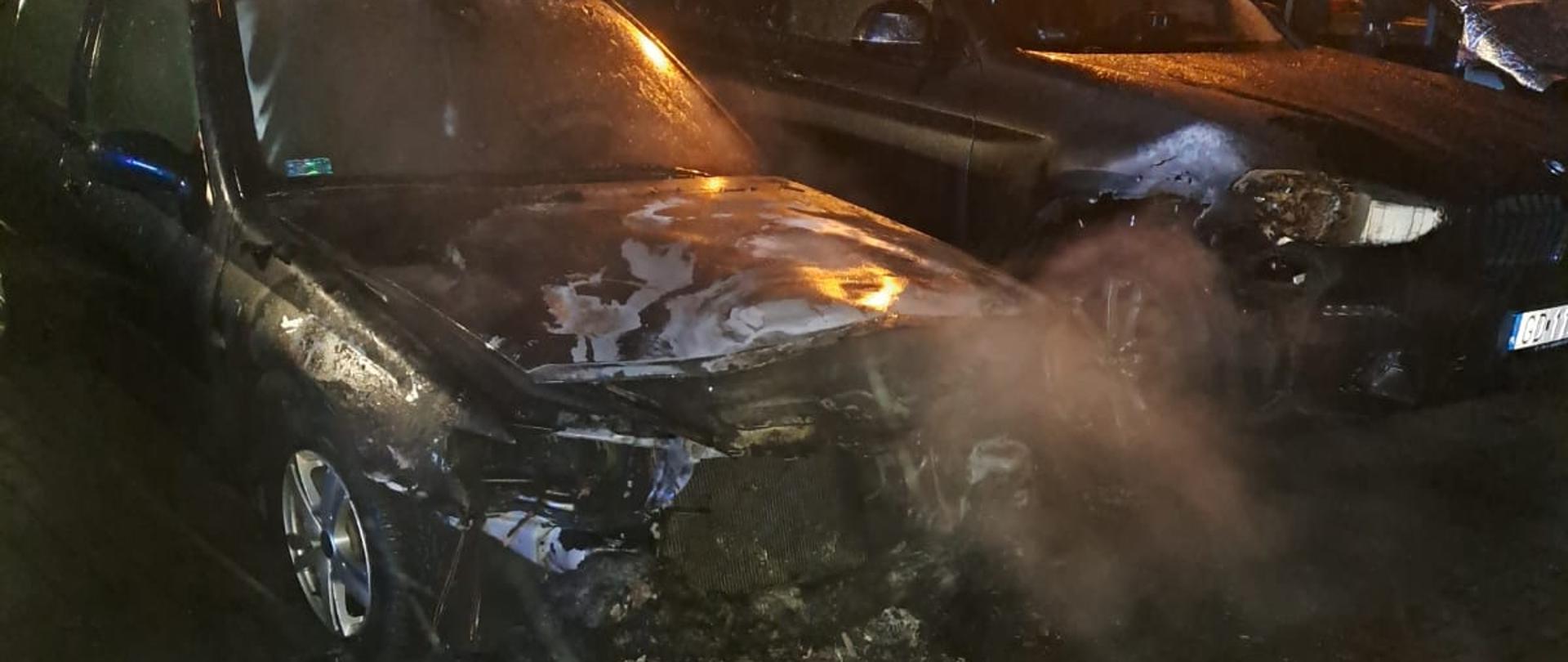 Na parkingu stoi zaparkowany samochód, który uległ spaleniu.