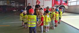 przedszkolaki ze strażakiem i samochodami pożarniczymi
