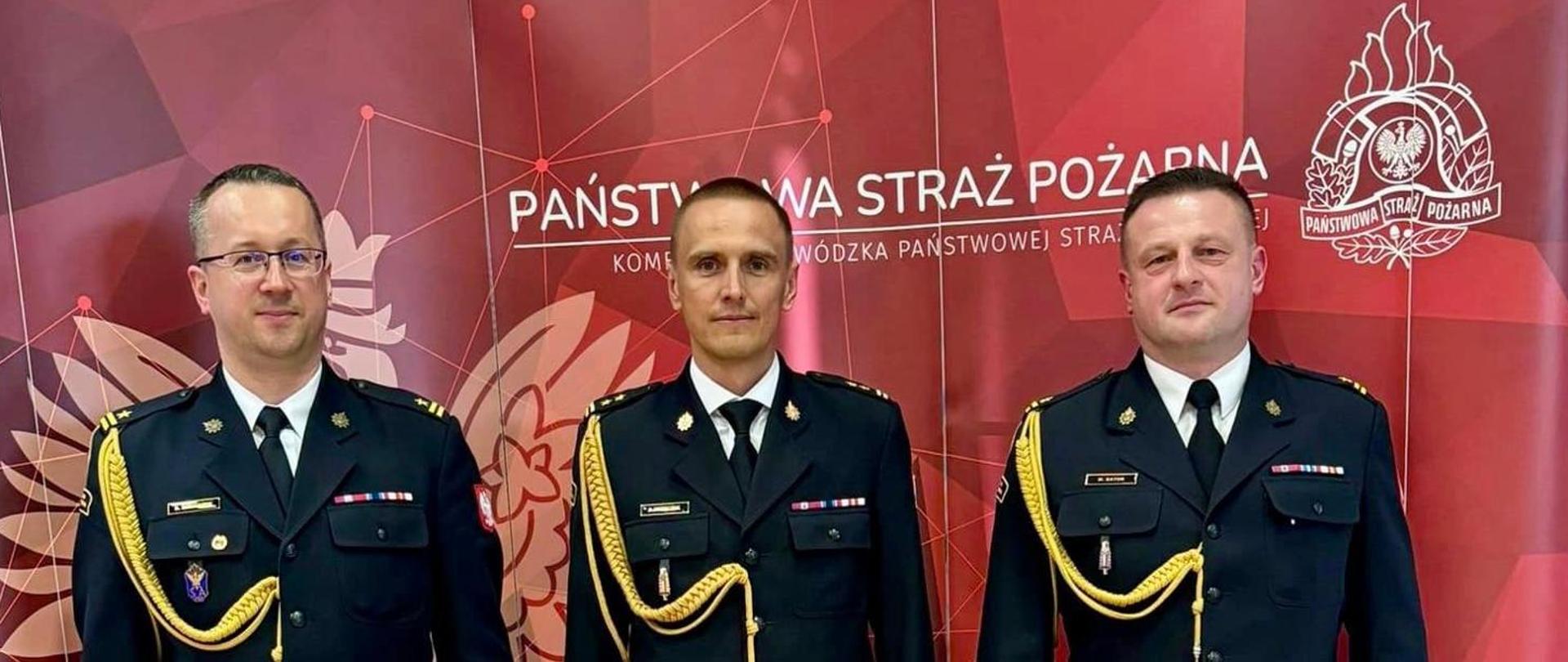 Na zdjęciu strażacy na tle baneru