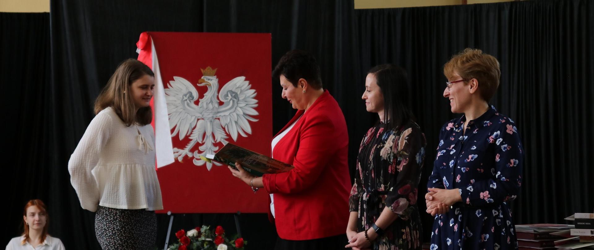 Na zdjęciu Dyrekcja Szkoły wręcza nagrodę uczennicy