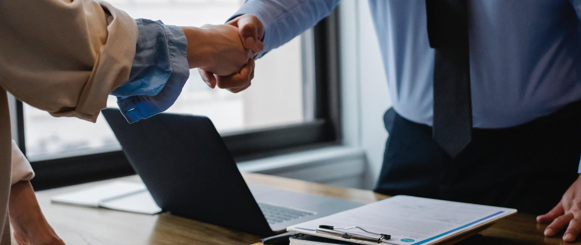 Zdjęcie autorstwa Sora Shimazaki z Pexels: https://www.pexels.com/pl-pl/zdjecie/upraw-koledzy-sciskajac-rece-w-biurze-5673488/