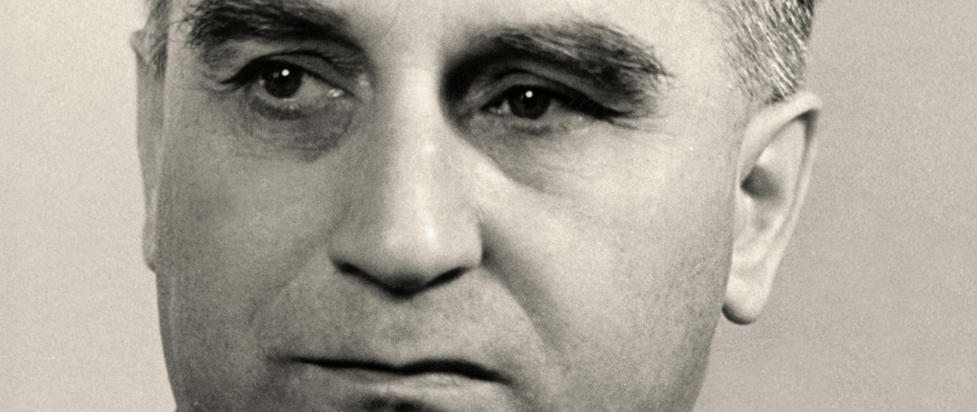 Stefan Jędrychowski czarno - biały portret łysiejącego mężczyzny, ciemne włosy, ciemna marynarka, ciemny krawat, biała koszula.