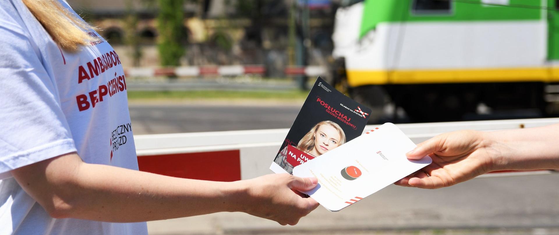 Wręczanie ulotki z informacjami o bezpieczeństwie na przejazdach