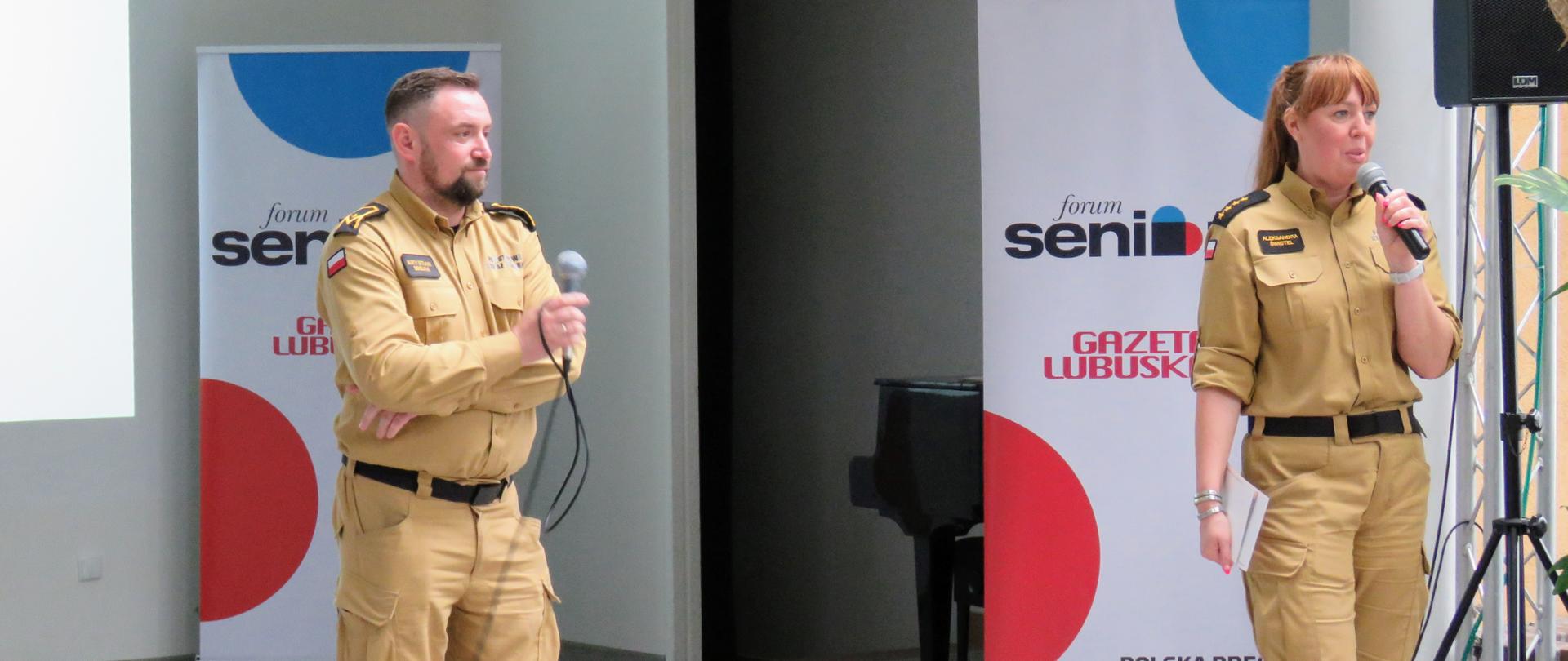 Prelekcja podczas "Forum Seniora" - strażacy na scenie prowadzący wykład