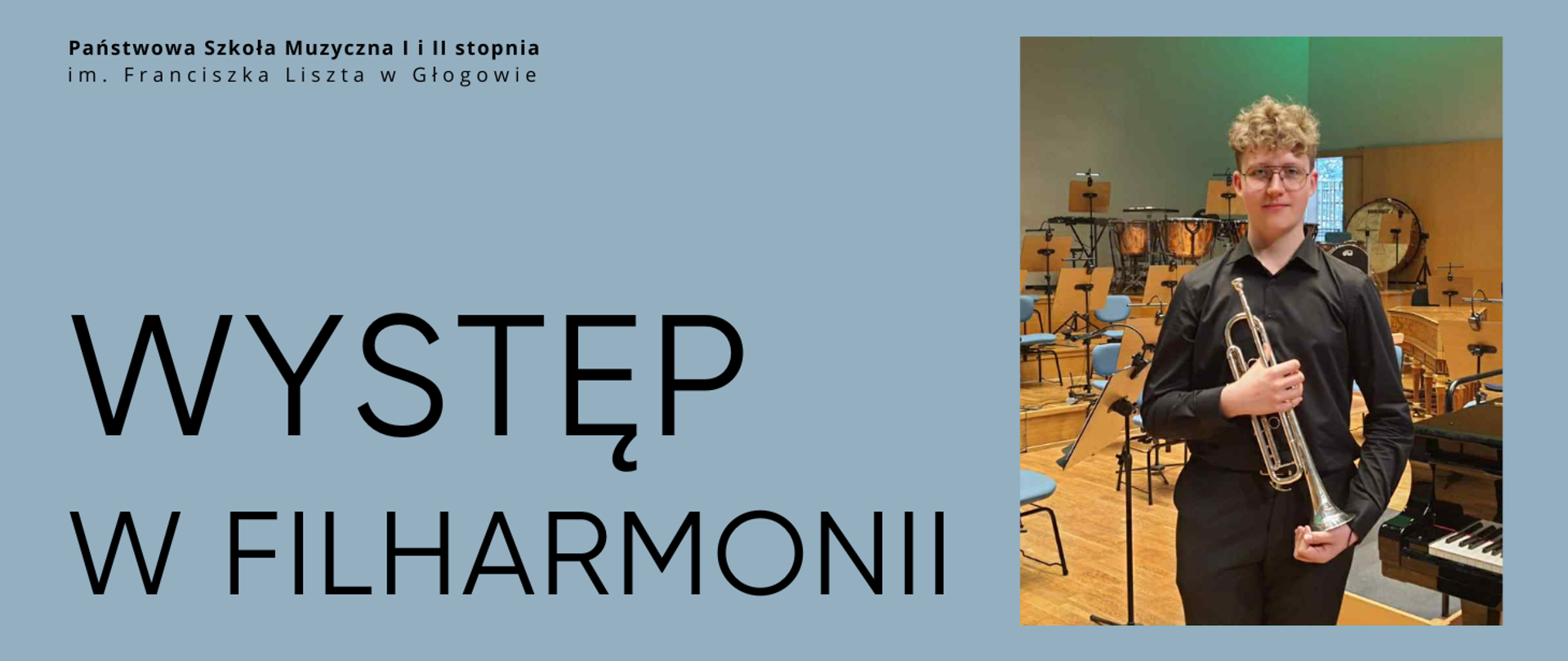 Grafika zawiera tekst: "WYSTĘP W FILHARMONII". Napis w lewej części obrazu, w dwóch rzędach, litery czarne. W lewym górnym rogu pełna nazwa szkoły, w dwóch rzędach, litery czarne. W prawej części zdjęcie chłopaka ubranego na czarno, w rękach trzyma trąbkę opuszczoną czarą do dołu. W tle wnętrze filharmonii, widoczne są pulpity, krzesła, instrumenty perkusyjne oraz fragment fortepianu. Tło grafiki niebieskie.