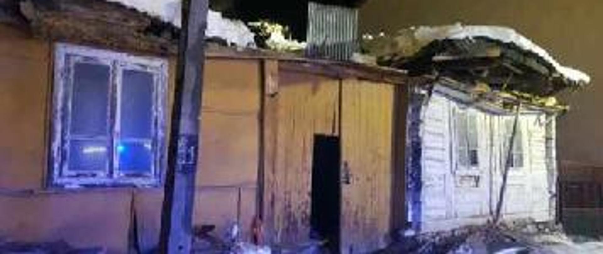 Zdjęcie przedstawia budynek mieszkalny, którego dach uległ zawaleniu. Widzimy wejście do budynku.