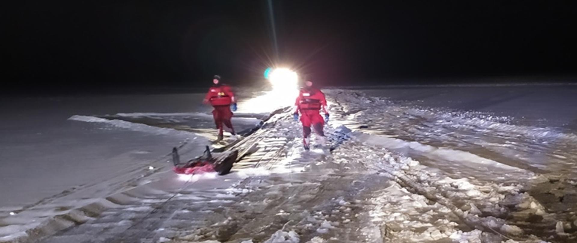 Ratownicy ze sprzętem ratownictwa wodno-lodowego na zamarzniętym jeziorze Kisajno