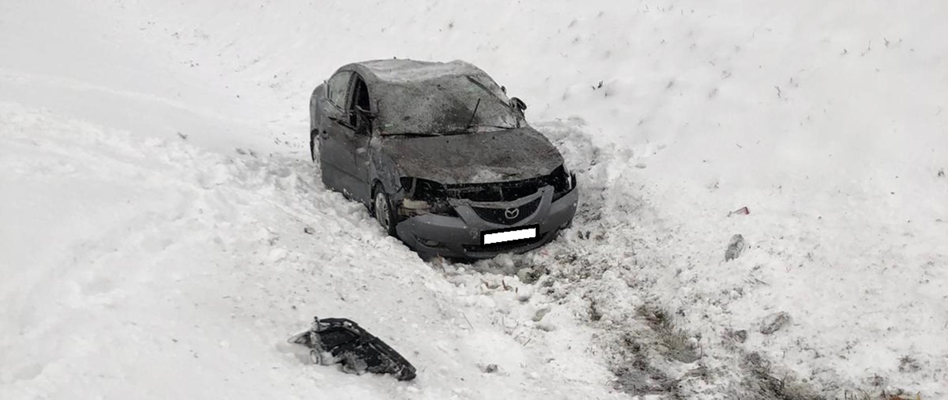 Samochód osobowy w rowie . Na ziemi śnieg.