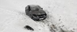 Samochód osobowy w rowie . Na ziemi śnieg.