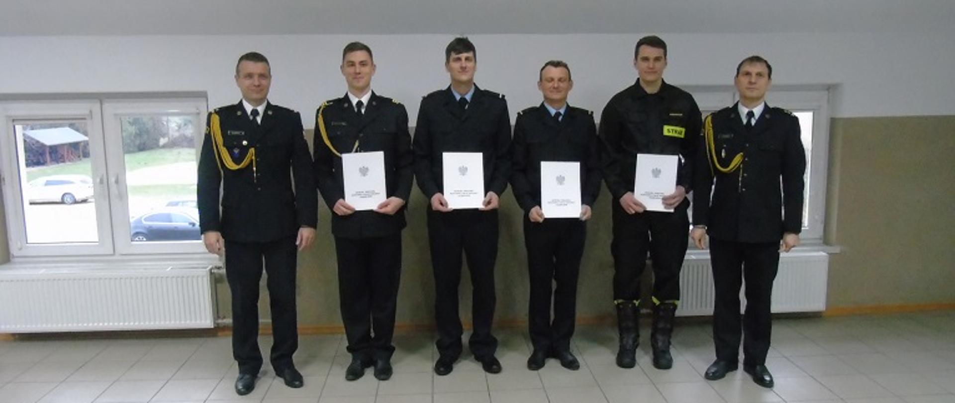 Zdjęcie przedstawia umundurowanych strażaków z KP PSP w Radziejowie w trakcie uroczystości wręczenia aktów nadania wyższych stopni służbowych.