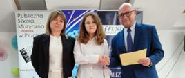 Na scenie Amelia Lewkowicz – II nagroda w kategorii III w czasie ogłoszenia wyników konkursy wraz z organizatorem Grzegorzem Wójcikiewiczem i nauczycielem Iwoną Grabowską. W tle znajdują się banery związane z wydarzeniem muzycznym oraz szkołą muzyczną w Pruchniku. 