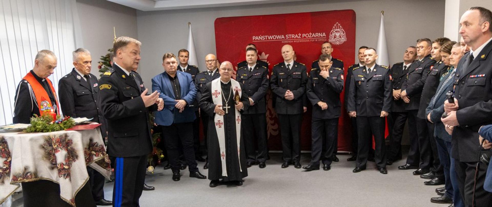 Przemówienie Opolskiego Komendanta Wojewódzkiego PSP. Uroczystość odbywa się w obecności funkcjonariuszy i zaproszonych gości.