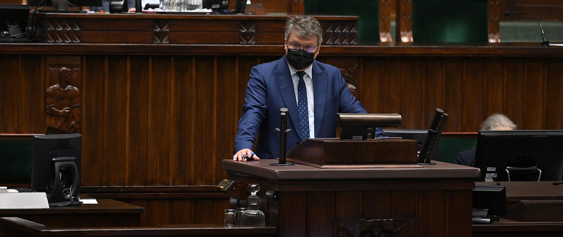Na zdjęciu widać wiceministra Macieja Wąsika zabierającego głos z mównicy sejmowej.