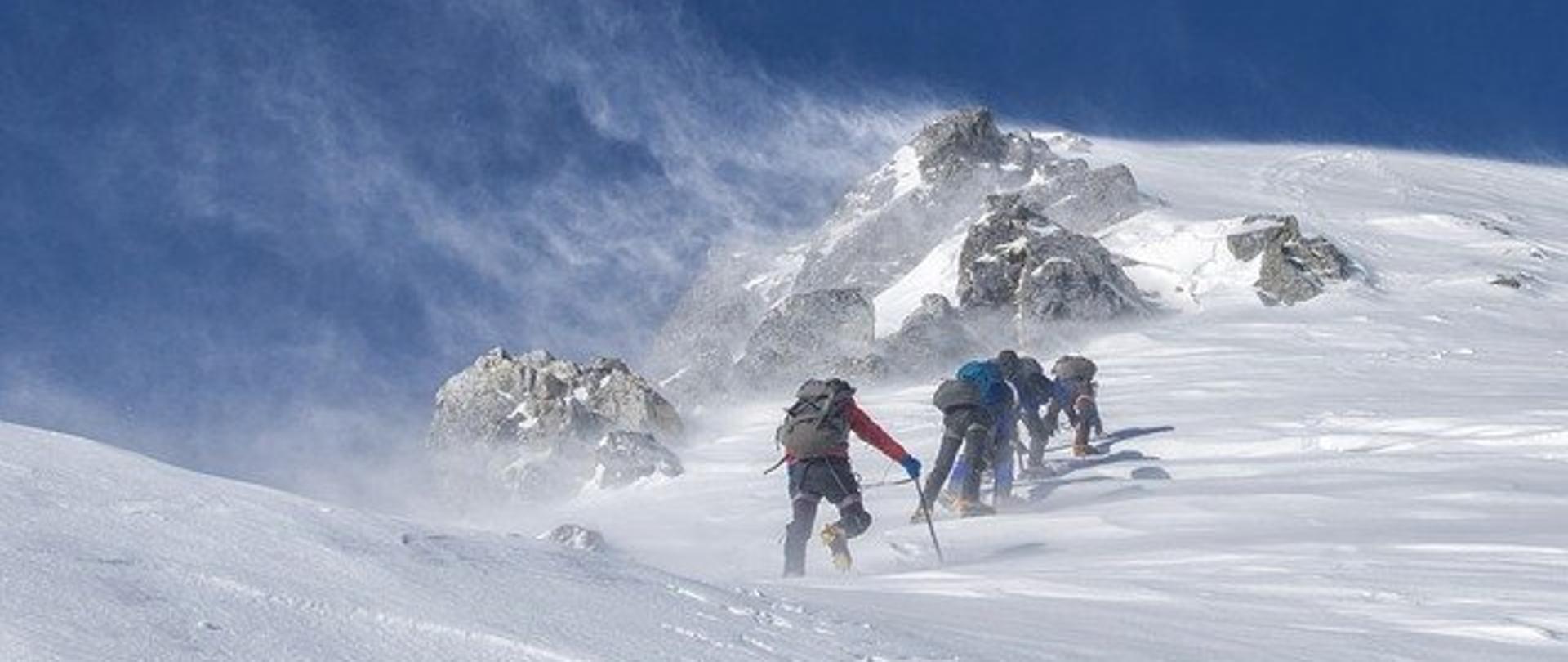 Górska wspinaczka zaśnieżonym szlakiem.