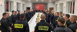 SPOTKANIE WIGILIJNE W KOŚCIAŃSKIEJ KOMENDZIE. Strażacy przy wspólnym stole podczas spotkania wigilijnego.