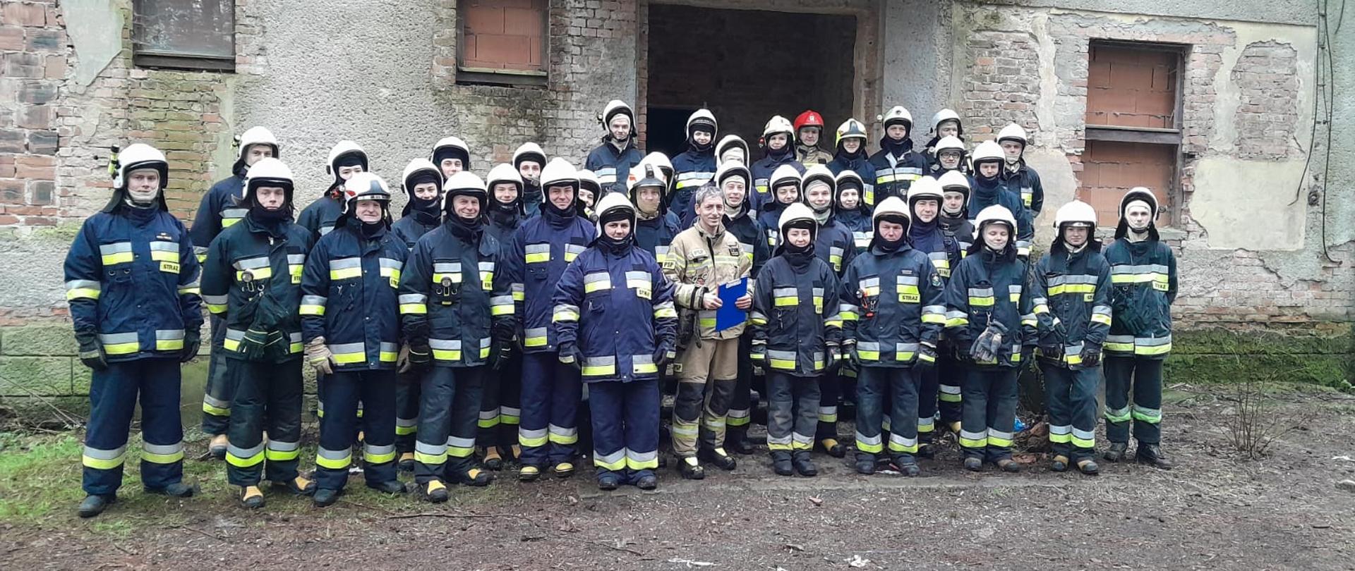 Druhowie OSP ubrani w ubrania specjalne, podczas zbiórki.
