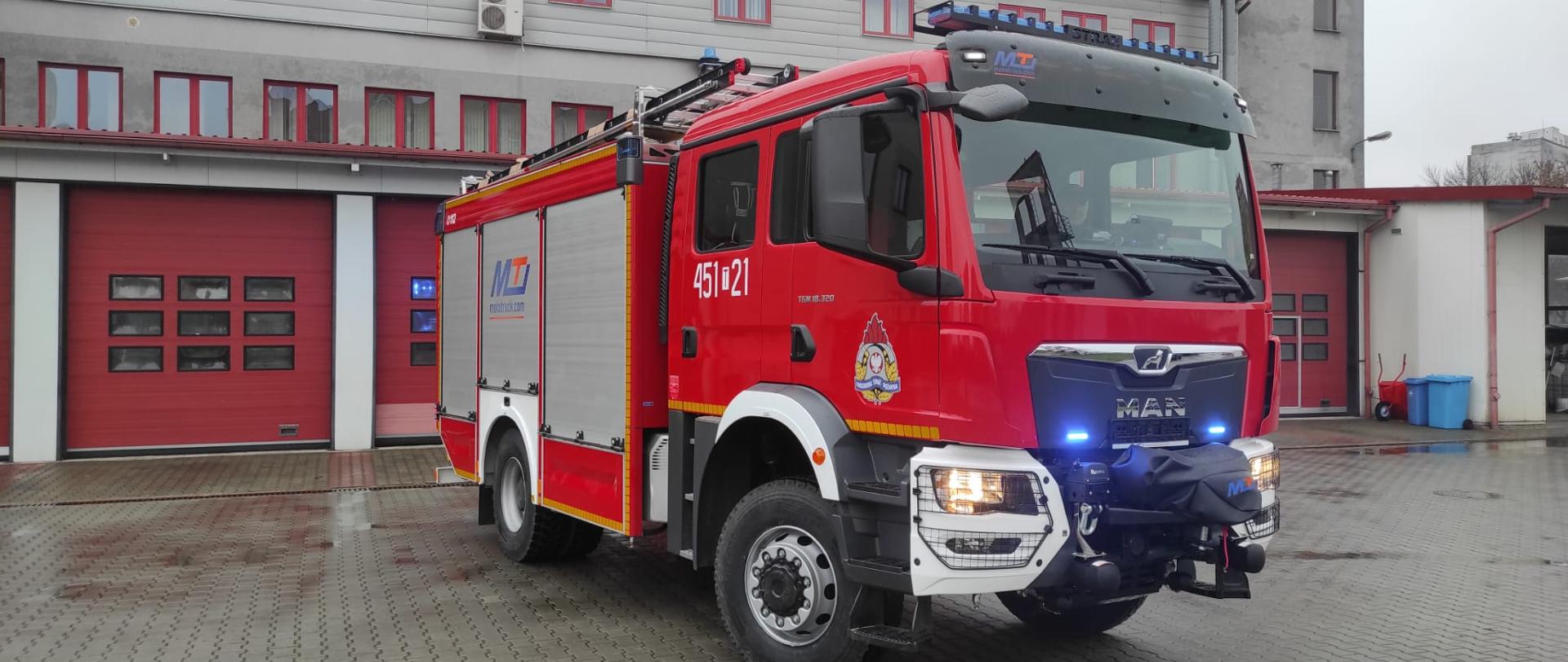 Samochód na placu z włączonymi sygnałami świetlnymi.