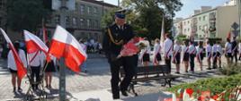 Strażak podczas składania kwiatów pod pomnikiem