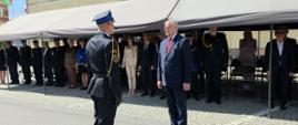 Dowódca uroczystości składa meldunek panu Wiceministrowi. W tle stoją zaproszeni goście.
