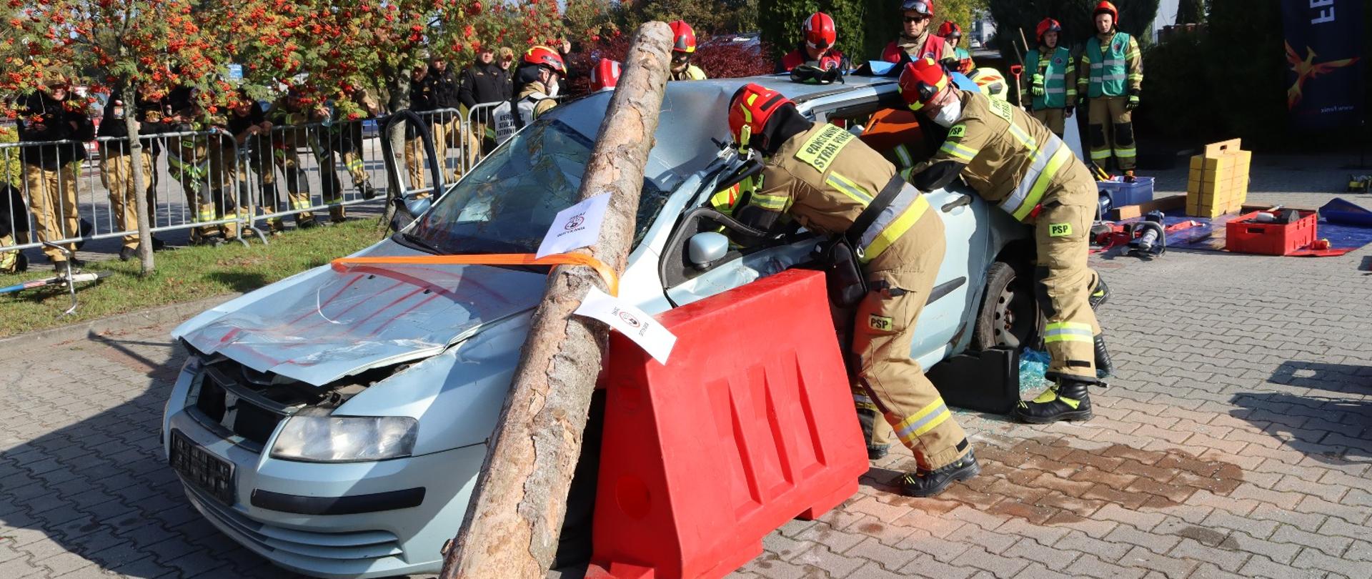 Ćwiczenia ratownictwa technicznego: strażacy PSP zabezpieczają auto i prowadzą ewakuację poszkodowanego podczas konkurencji.