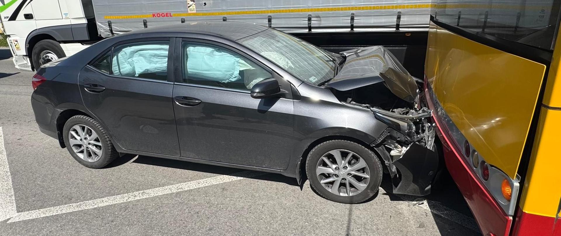 Zdjęcie przedstawia z lewej strony tył autobusu miejskiego w który uderzył samochód osobowy.