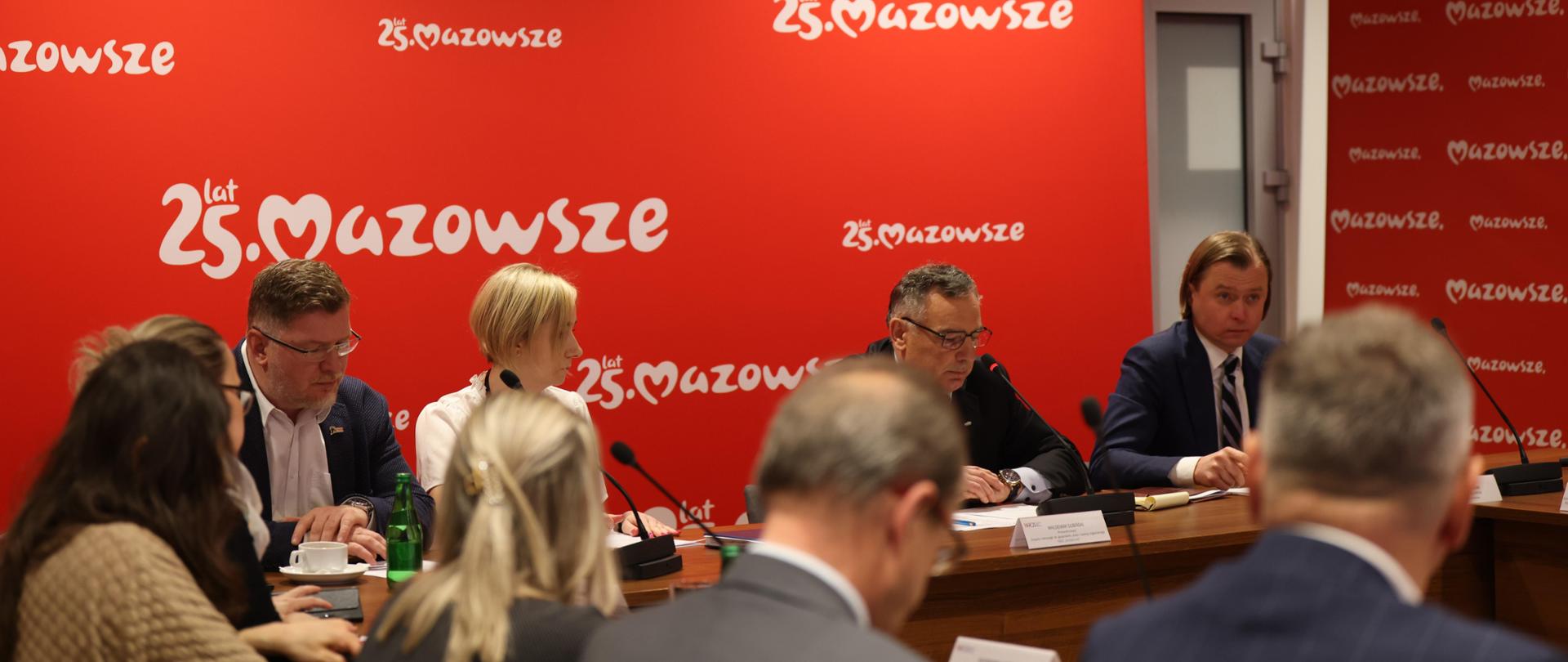 Na zdjęciu grupa ludzi w sali. Biorą udział w spotkaniu. 