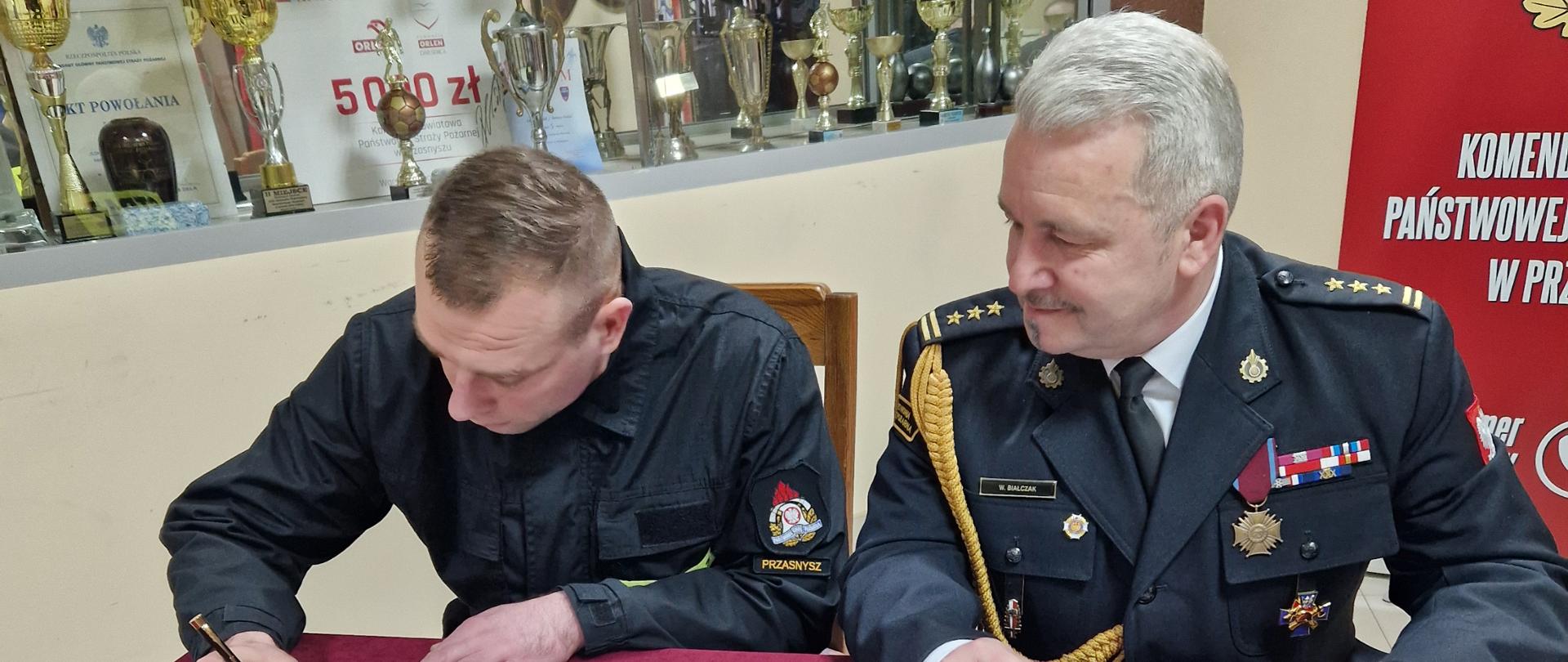 Dnia 6 lutego 2024 roku w siedzibie Komendy Powiatowej Państwowej Straży Pożarnej w Przasnyszu odbyło się uroczyste ślubowanie str. Łukasza Kowalskiego.
Ślubowanie przyjął Komendant Powiatowy PSP w Przasnyszu st.bryg. Waldemar Białczak.
Uroczystość z udziałem kadry Komendy oraz Jednostki Ratowniczo-Gaśniczej w Przasnyszu poprowadził Z-ca Komendanta Powiatowego PSP w Przasnyszu bryg. Jarosław Andruszkiewicz.
Słowem wstępu Komendant Powiatowy nawiązał do roty ślubowania, podkreślając znaczenie tej chwili w życiu zawodowym każdego strażaka. Zaznaczył także, że funkcjonariusz reprezentuje tą formację nie tylko w czasie służby, ale także poza nią. Podkreślił, że służba w Straży Pożarnej nie jest łatwa i wymaga oddania oraz wielkiego serca do pracy. Życzył nowo przyjętemu funkcjonariuszowi samych sukcesów i ukończenia kursu podstawowego z jak najlepszymi wynikami.
Podejmując służbę w Państwowej Straży Pożarnej, strażak składa ślubowanie według następującej roty:
„Ja, obywatel Rzeczypospolitej Polskiej, świadom podejmowanych obowiązków strażaka, uroczyście ślubuję być ofiarnym i mężnym w ratowaniu zagrożonego życia ludzkiego i wszelkiego mienia - nawet z narażeniem życia. Wykonując powierzone mi zadania, ślubuję przestrzegać prawa, dyscypliny służbowej oraz wykonywać polecenia przełożonych. Ślubuję strzec tajemnic związanych ze służbą, a także honoru, godności i dobrego imienia służby oraz przestrzegać zasad etyki zawodowej.”.
Po wypowiedzeniu słów roty str. Łukasz Kowalski podpisała formularz aktu ślubowania, który przyjął i podpisał Komendant Powiatowy.
Opracowanie: kpt. Piotr Kuligowski.
Zdjęcia: asp. Rafał Sekuna.
