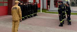 Strażacy stoją w szeregu podczas zmiany służby.