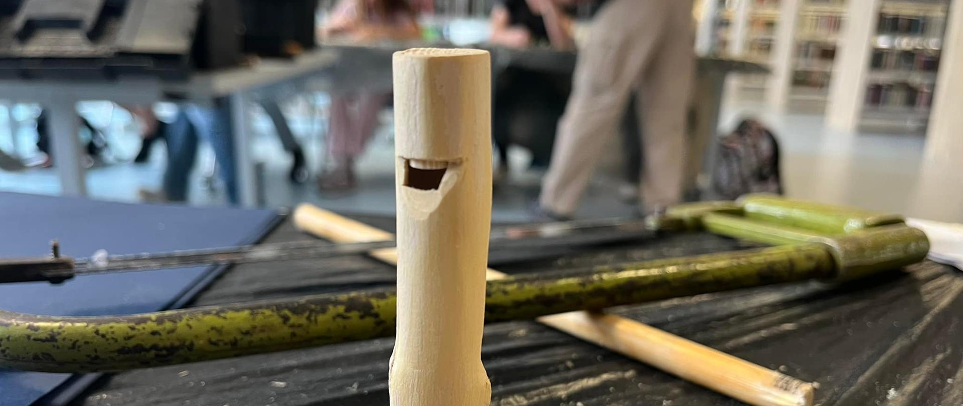 Piszczałka zrobiona ręcznie przez dzieci z kawałka drewna na drewnianej podstawce