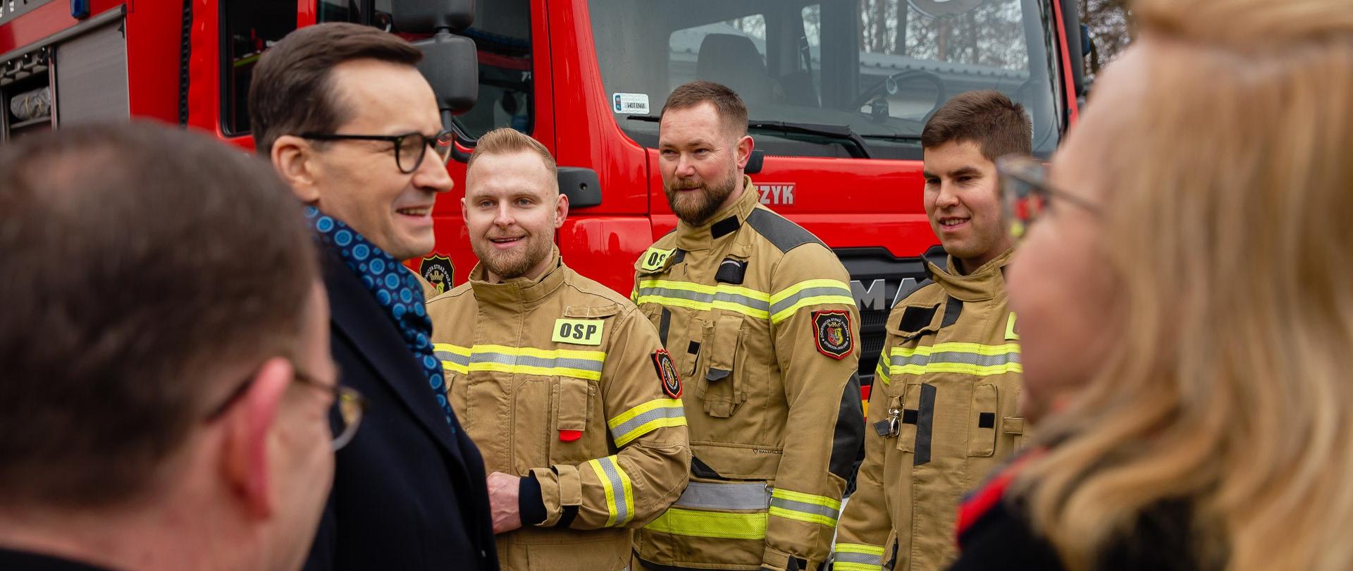 Premier Mateusz Morawiecki rozmawia ze strażakami.