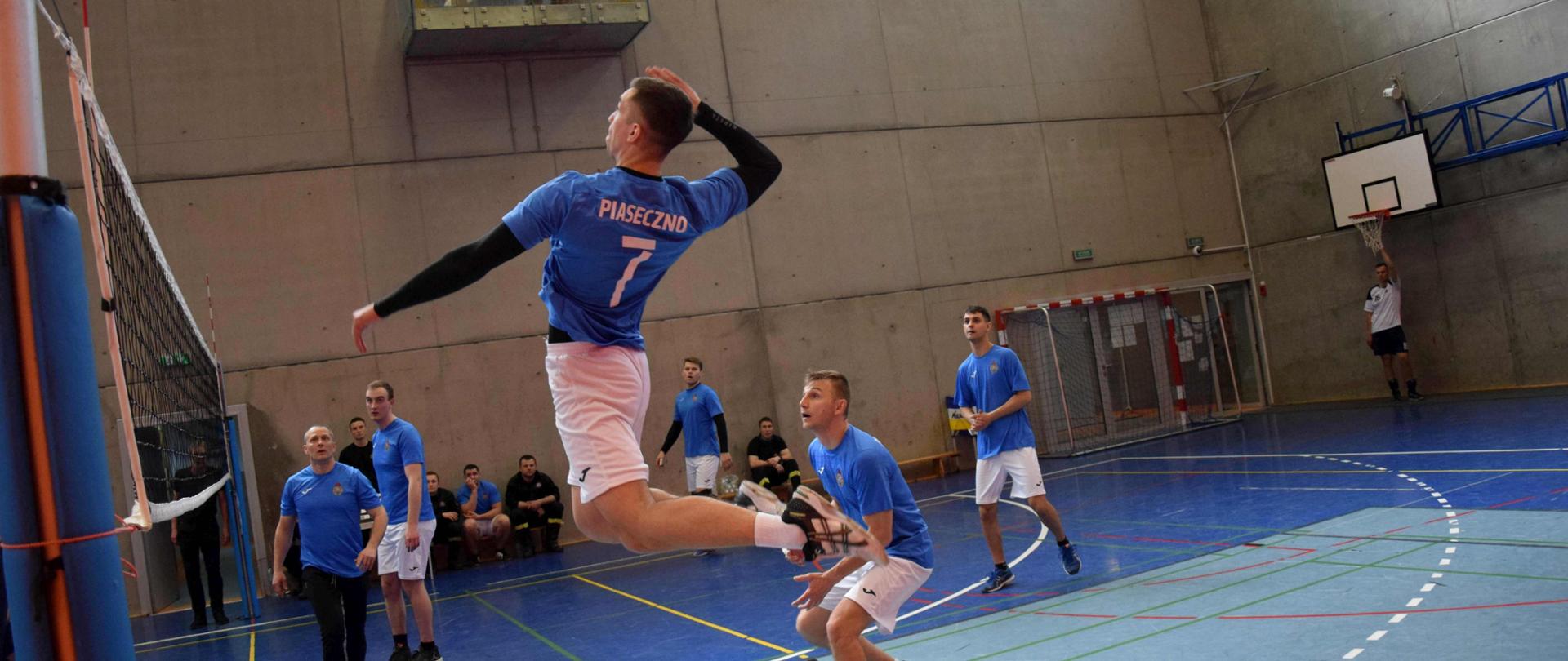 Mecz piłki siatkowej. Przy piłce drużyna z KP PSP w Piasecznie. Atak z wyskoku. 