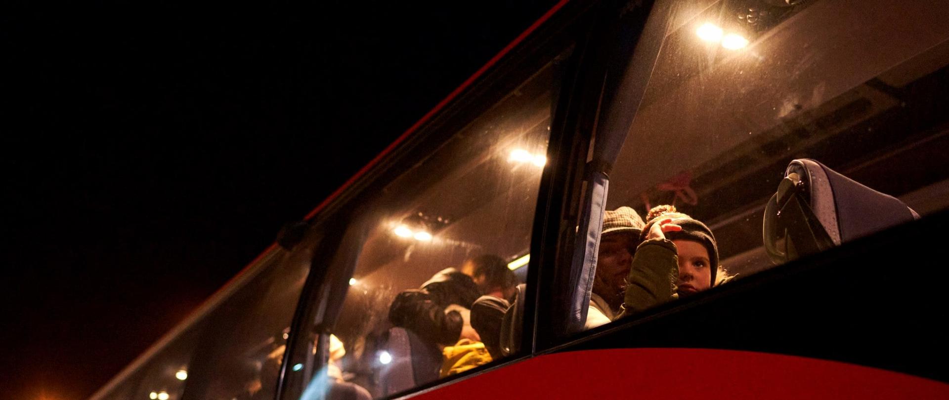 Na zdjęciu widać autobus Państwowej Straży Pożarnej gotowy do odjazdu . W autobusie znajdują się matki z dziećmi 