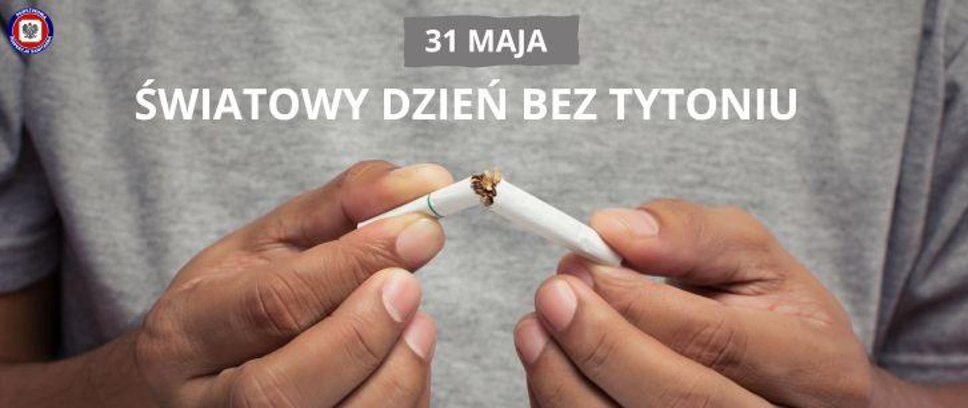 Kadr męskich dłoni trzymających złamanego papierosa. W tle jasnoszara koszulka. Na środku powyżej jasny napis na ciemnoszarym polu 31 maja, poniżej jasny napis Światowy Dzień bez Tytoniu. W lewym górnym rogu logo Państwowej Inspekcji Sanitarnej.