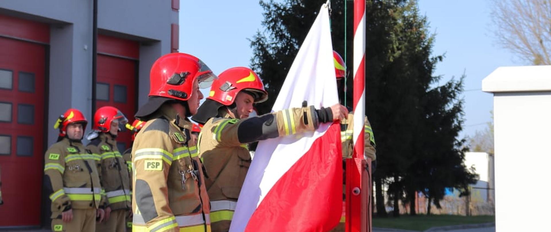 Na zdjęciu poczet flagowy przygotowujący flagę do uroczystego podniesienia