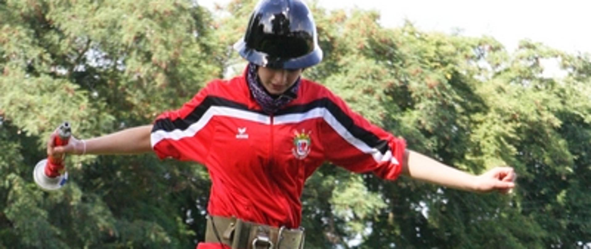 Zdjęcie przedstawia zawodniczkę podczas biegu w sztafecie pożarniczej