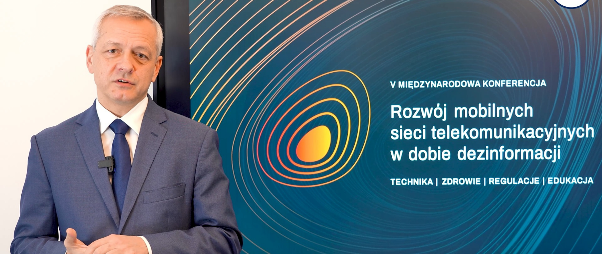 Minister Marek Zagórski podczas wystąpienia. Za nim ekran z logo i tytułem konferencji.