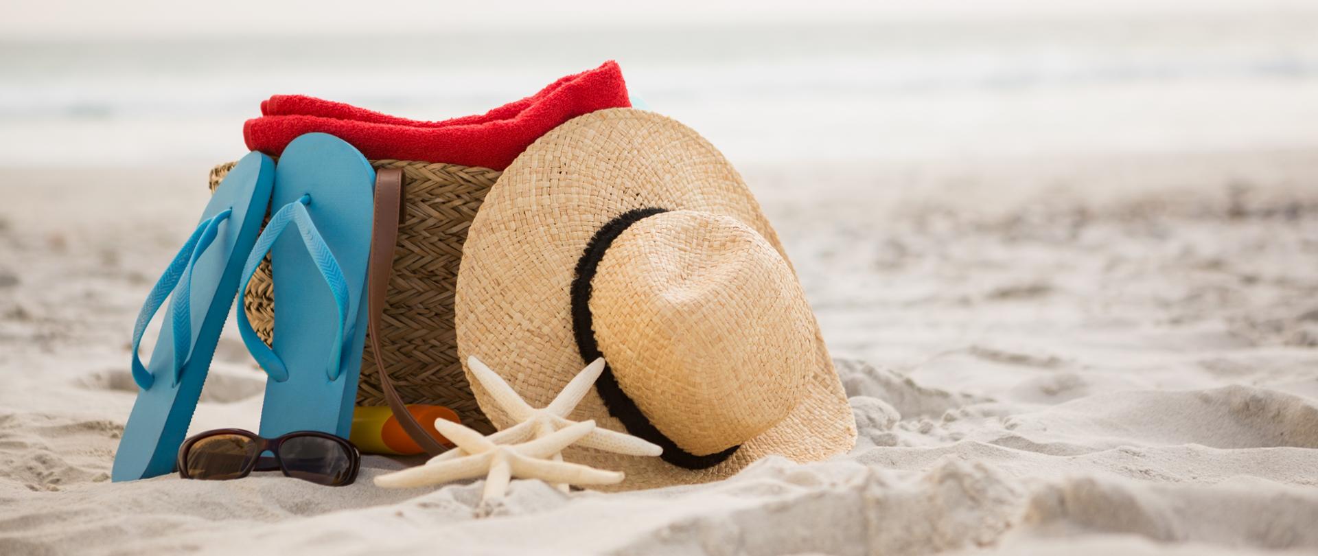 Bag and beach accessories kept on sand at beach