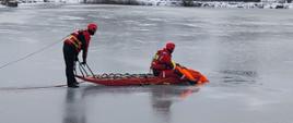 Zdjęcie przedstawia ratowników podczas ćwiczeń na lodzie z użyciem sań lodowych.